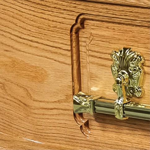 Brass bar handle on the routed panel side of The Devonshire solid oak coffin